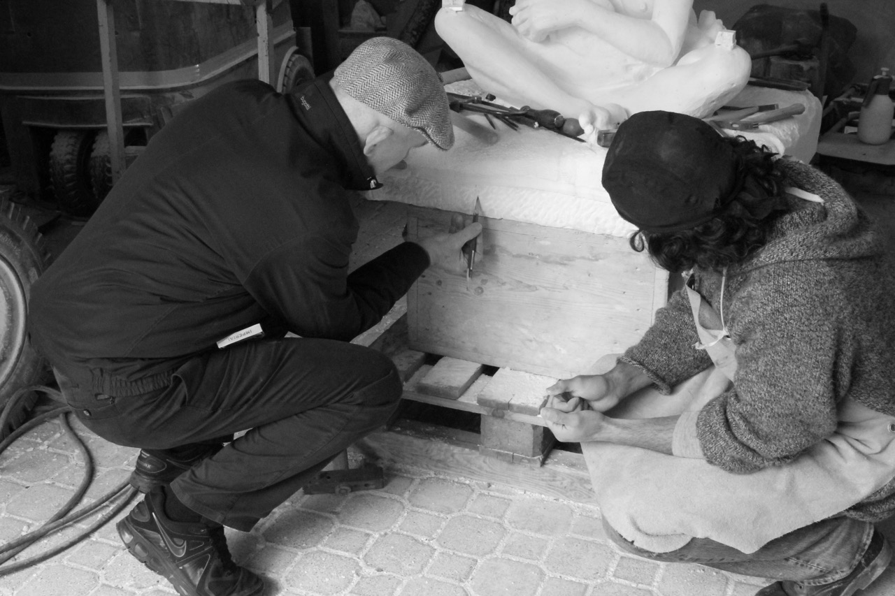 Paddy observes Dario chiselling the delicate patterns on the cushion